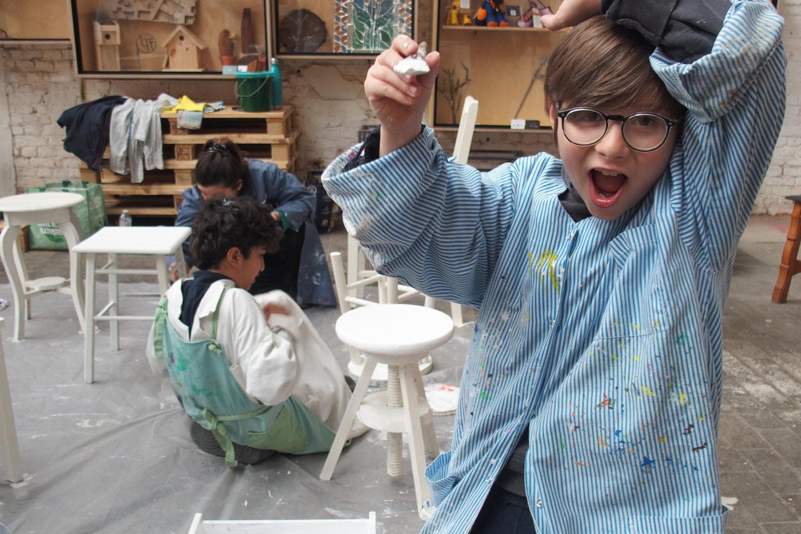 Les enfants de l'école de devoirs La Place à l'atelier de peinture sur meubles